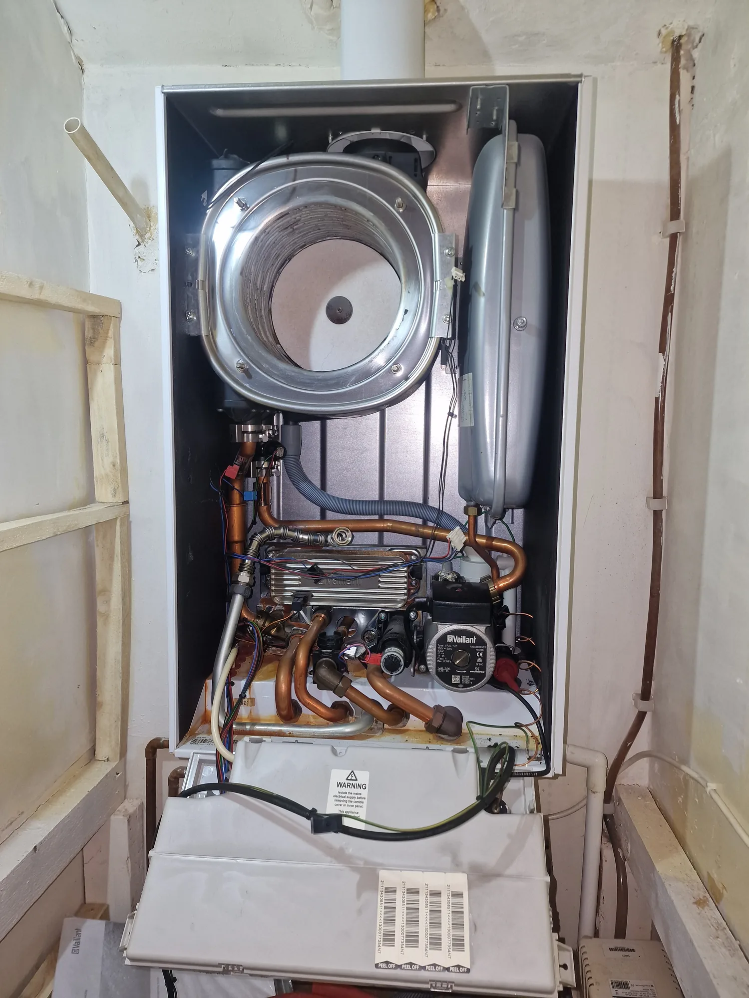 Boiler heat exchanger, pump and pipework exposed during a repair